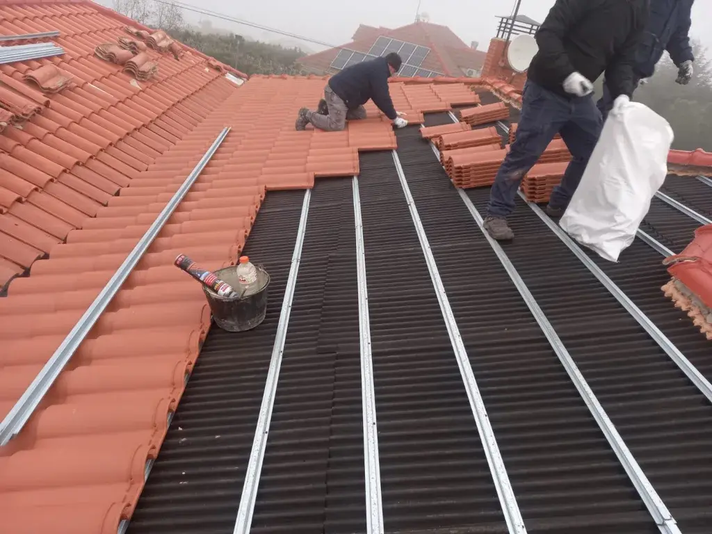 Operarios trabajando en la cubierta de una vivienda unifamiliar